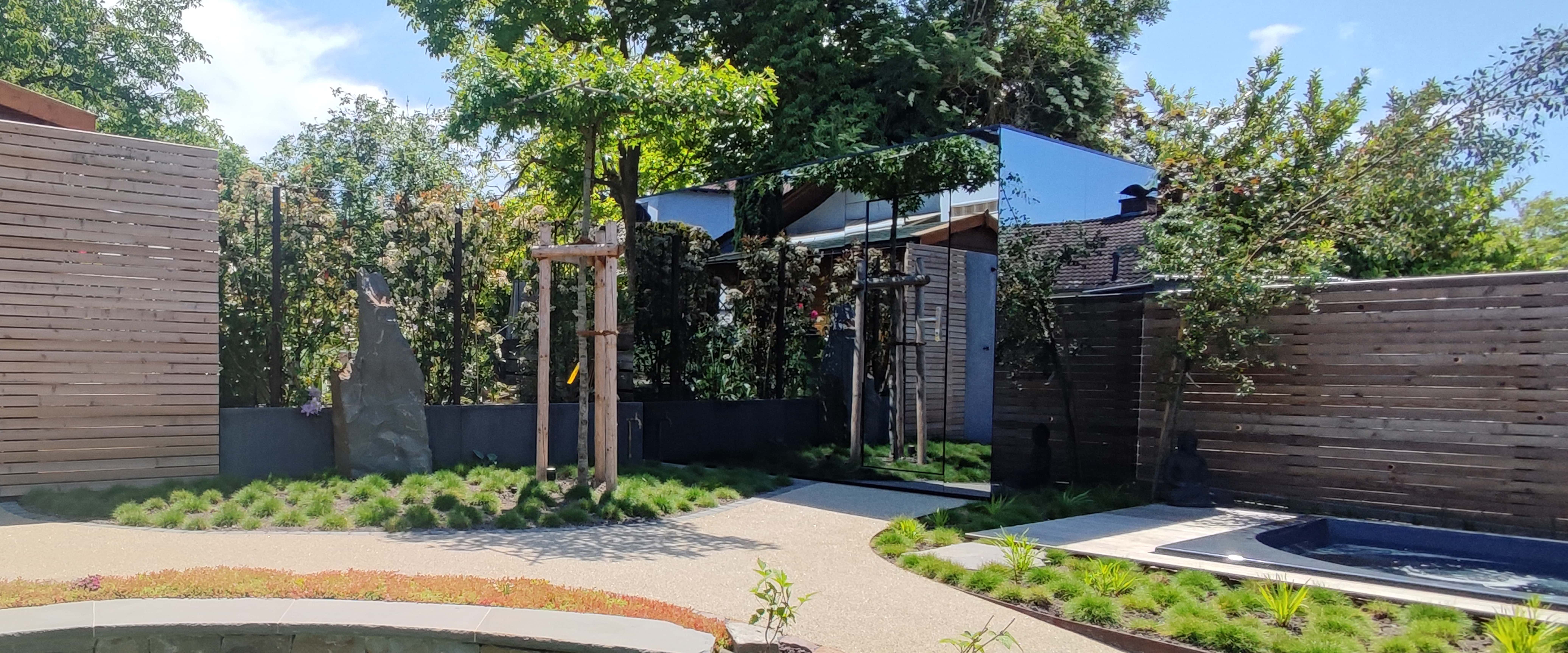 Saunahaus mit Spiegelfassade im Garten.